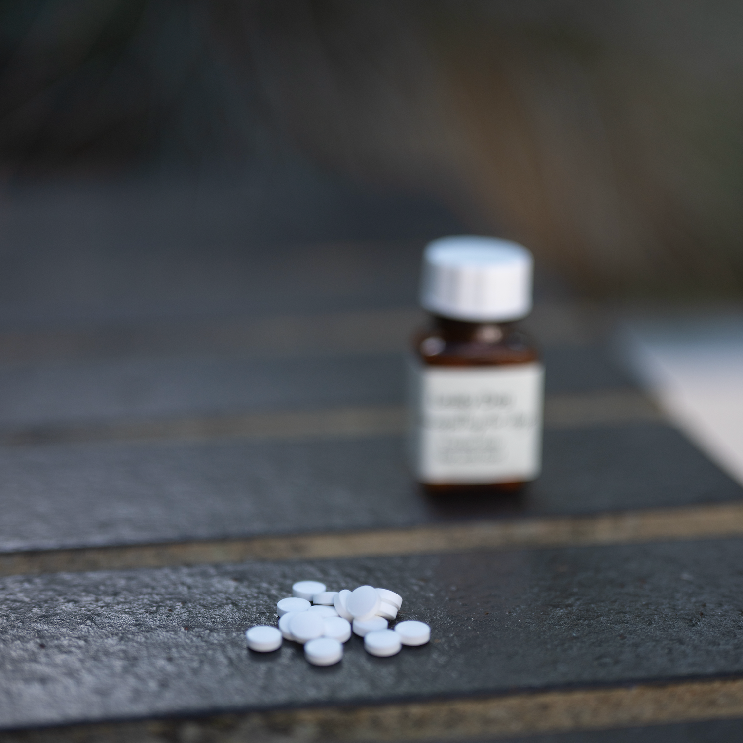 Bereavement Special tablets for dogs grieving a loss, with a bottle and tablets displayed on a wooden surface.