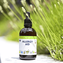 Allergy Aid pet remedy bottle surrounded by green plants, promoting relief for pets with allergies.